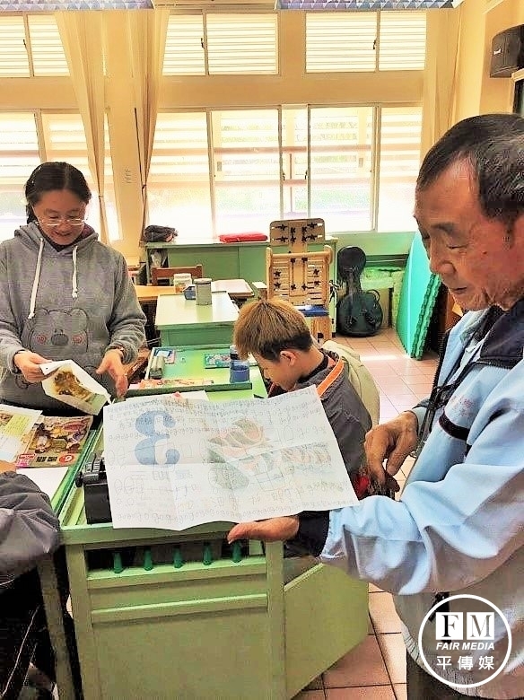 呂岳駿的阿公（右）代為唸出來自大雅國中姊姊的鼓勵。（啟明學校提供）
