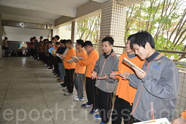 台中啟明學校師生以人龍接力方式，將書本從二樓傳遞到一樓的圖書室。（賴瑞/大紀元）